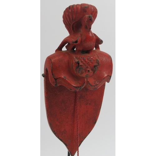 229 - A Southeast Asian red lacquered and carved wood plumb line. Modelled with surmounted bird and cord s... 