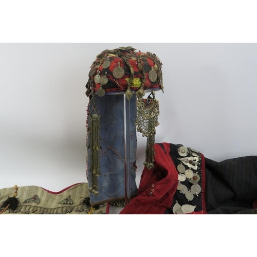 230 - A vintage Bedouin women’s headdress, children's tunic and men's coat, probably 19th century. Profuse... 