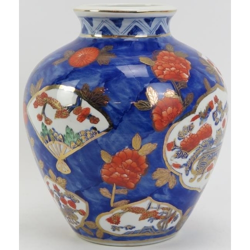 235 - A Japanese Imari porcelain vase, 20th century. Decorated with panels and flowers against a blue grou... 