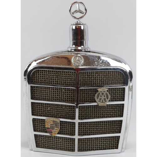 254 - Automobilia: A vintage Mercedes Benz car grill drinks decanter flask and two car bonnet emblems, mid... 