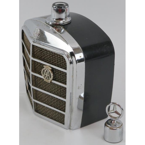 254 - Automobilia: A vintage Mercedes Benz car grill drinks decanter flask and two car bonnet emblems, mid... 