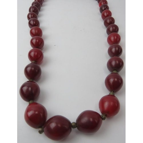 281 - Tribal Art: A vintage African simulated cherry red amber glass necklace. 86 cm approximate length. 
... 