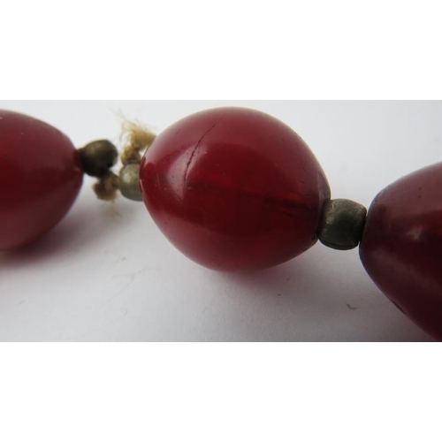 281 - Tribal Art: A vintage African simulated cherry red amber glass necklace. 86 cm approximate length. 
... 