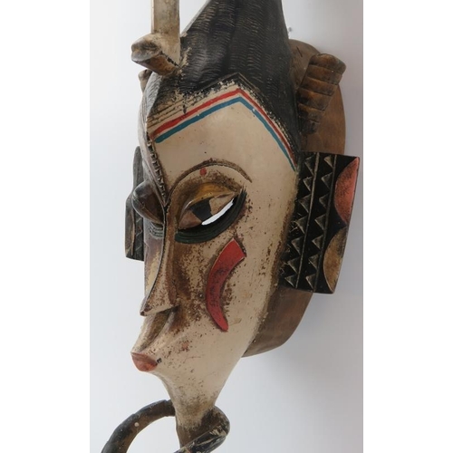 284 - Tribal Art: An African carved and painted wood mask, Baule (Baoulé) people, Cameroon. Depicted with ... 