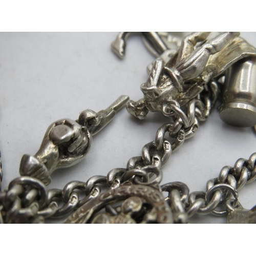 302 - Two possibly silver link bracelets joined together with a large amount of silver & white metal charm... 