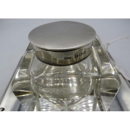 375 - A heavy square glass inkwell with star cut base, silver hinged lid, sitting in a silver galleried sq... 