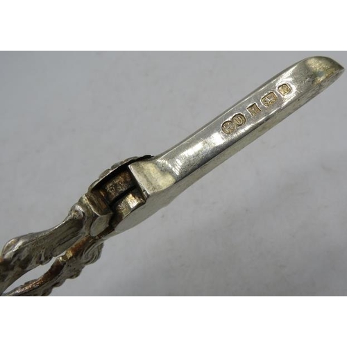 413 - A pair of silver grape scissors heavily embossed with vine decoration, Birmingham 1985. Approx weigh... 