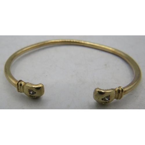 433 - A 9ct yellow gold bangle with boxing glove terminals each set with a white stone. Approx weight 5.5 ... 