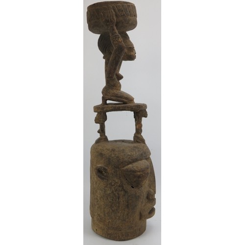 288 - Tribal Art: A large African carved wood head surmounted by figures, the upper figure holding an offe... 