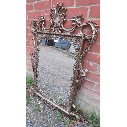 709 - A vintage gilt brass wall mirror in the George II taste, having a very ornate pierced surround model... 