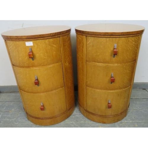 715 - A pair of Art Deco bird’s eye maple cylindrical bedside chests, each housing three graduated drawers... 