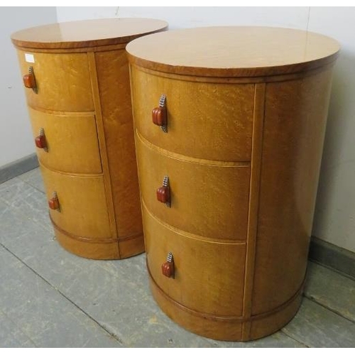 715 - A pair of Art Deco bird’s eye maple cylindrical bedside chests, each housing three graduated drawers... 