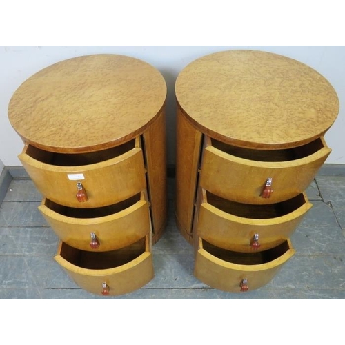 715 - A pair of Art Deco bird’s eye maple cylindrical bedside chests, each housing three graduated drawers... 