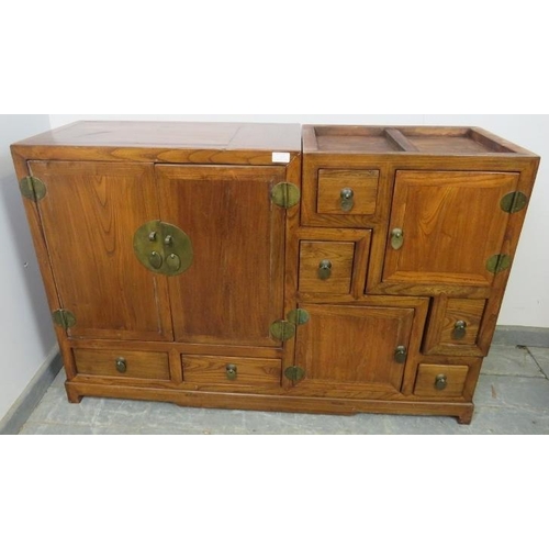 717 - A vintage Chinese elm stepped room-divider, housing an array of six double-sided drawers and three c... 