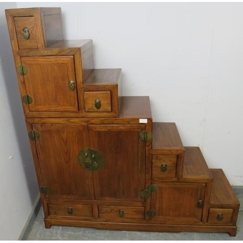 717 - A vintage Chinese elm stepped room-divider, housing an array of six double-sided drawers and three c... 