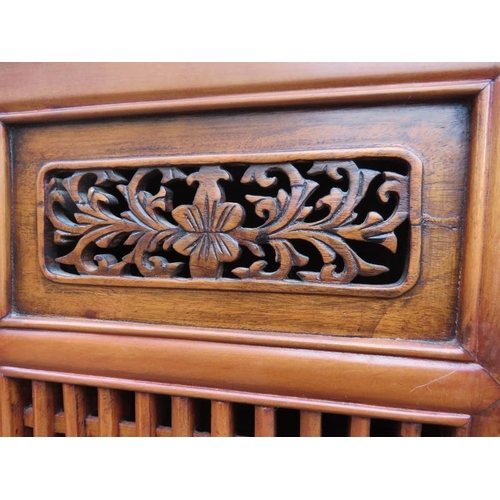 719 - A vintage Chinese elm kitchen cupboard, having carved and pierced decoration and slatted doors openi... 