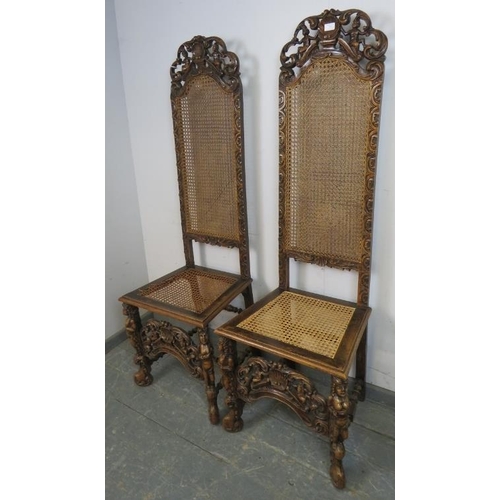 722 - A pair of 19th century fruitwood high back bergère hall chairs in the Carolean taste, the carved and... 