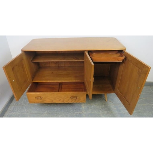 727 - A mid-century blonde elm and beech Windsor sideboard by Ercol (model 467) having cupboard doors encl... 