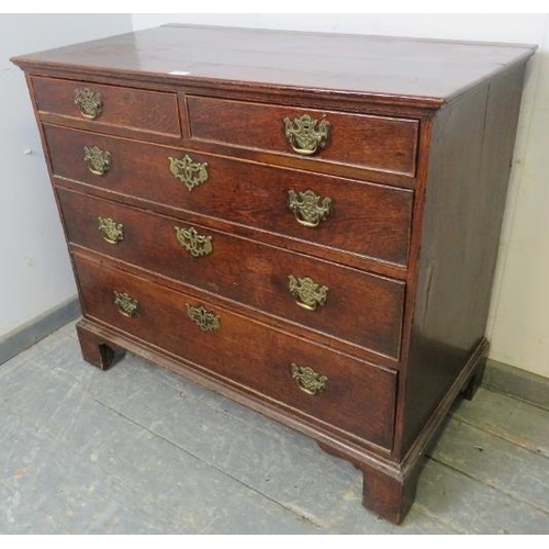 730 - An 18th century oak chest of two short over three long graduated, cock-beaded drawers with pierced b... 