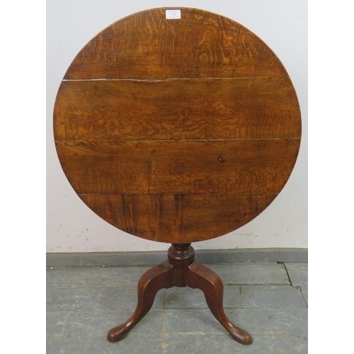 734 - A George III medium oak tilt-top supper table, on a turned pedestal with splayed tripod supports. 
H... 