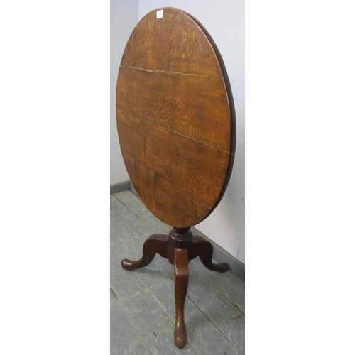 734 - A George III medium oak tilt-top supper table, on a turned pedestal with splayed tripod supports. 
H... 