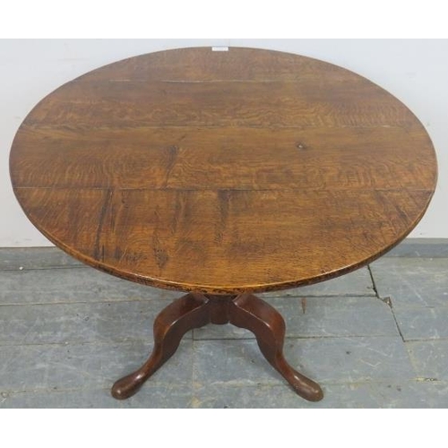 734 - A George III medium oak tilt-top supper table, on a turned pedestal with splayed tripod supports. 
H... 