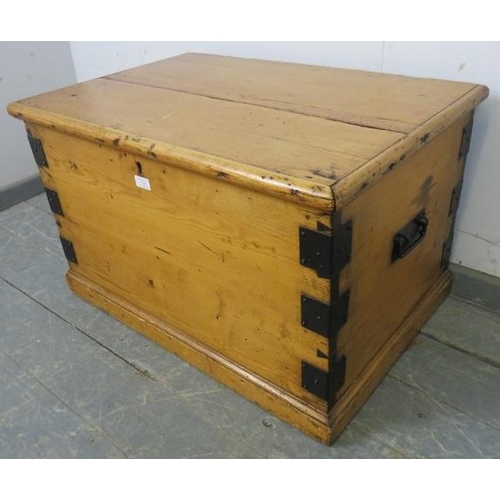 736 - An antique pine flat topped trunk/blanket box, metal bound and having handles to with side, on a pli... 