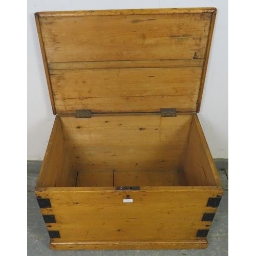 736 - An antique pine flat topped trunk/blanket box, metal bound and having handles to with side, on a pli... 