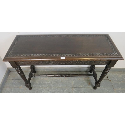 743 - A 19th century mahogany narrow hall table in the Gothic taste, having relief carved top above an aca... 