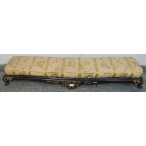 744 - A 19th century long low footstool, with loose cushion, the ebonised base with relief decoration pain... 