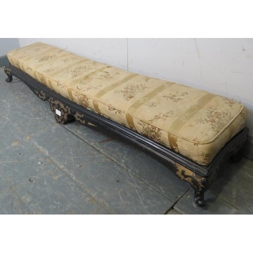 744 - A 19th century long low footstool, with loose cushion, the ebonised base with relief decoration pain... 