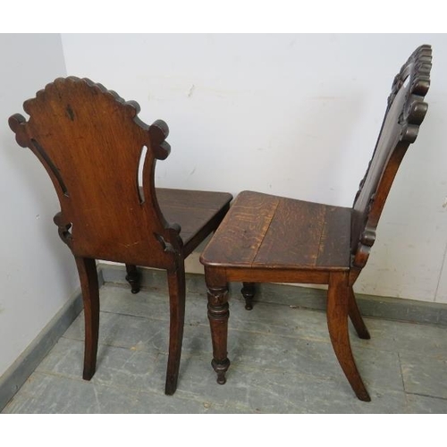 750 - A pair of 19th century oak hall chairs, having scroll carved and pierced backs, on carved tapered fr... 