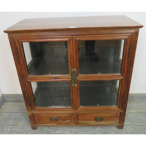 762 - A vintage Chinese elm glazed display cabinet, having one loose shelf, above two short drawers with c... 