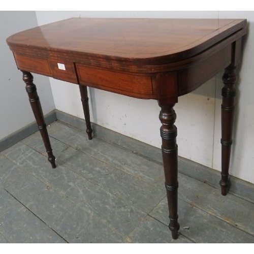 765 - A George III mahogany turnover card table of good colour, strung with ebony, on tapered turned suppo... 