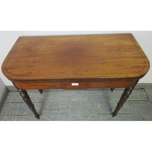 765 - A George III mahogany turnover card table of good colour, strung with ebony, on tapered turned suppo... 