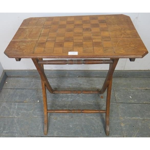 767 - An Edwardian walnut folding table with chessboard top, on curved supports with turned stretchers. 
H... 