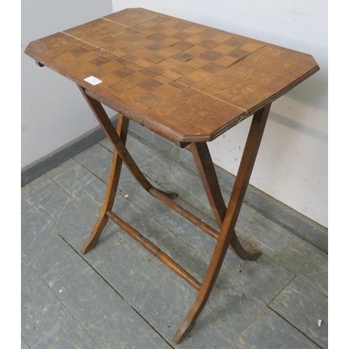 767 - An Edwardian walnut folding table with chessboard top, on curved supports with turned stretchers. 
H... 