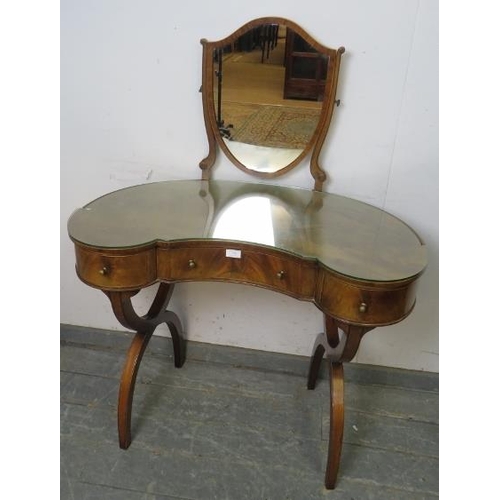 770 - A vintage mahogany kidney-shaped dressing table in the Regency style, having a shield shaped mirror ... 