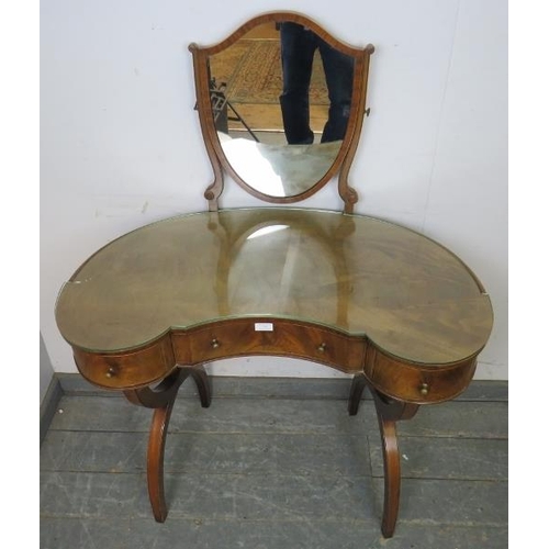 770 - A vintage mahogany kidney-shaped dressing table in the Regency style, having a shield shaped mirror ... 