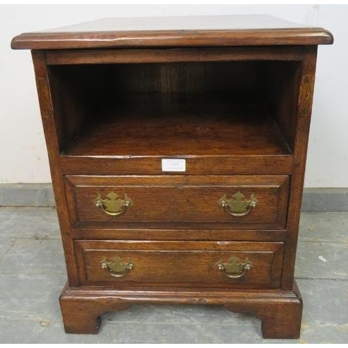 777 - A reproduction 18th century style solid oak bedside chest, having an open shelf above two long drawe... 