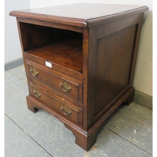 777 - A reproduction 18th century style solid oak bedside chest, having an open shelf above two long drawe... 