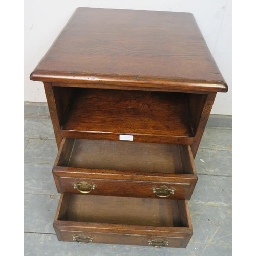 777 - A reproduction 18th century style solid oak bedside chest, having an open shelf above two long drawe... 