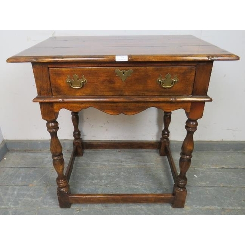 778 - A good quality solid oak side table in the 18th century taste, having one long drawer with brass bat... 