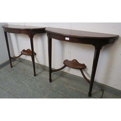 789 - A pair of Edwardian mahogany demi-lune console tables, strung with ebony, on tapered square supports... 