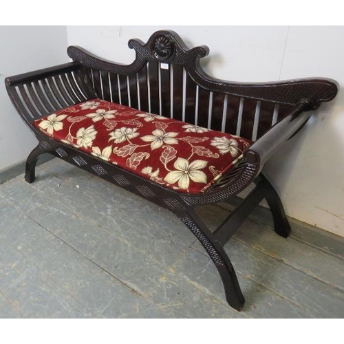 805 - An antique style ebonised hardwood love seat, with shaped cornice and slatted back, upholstered in a... 