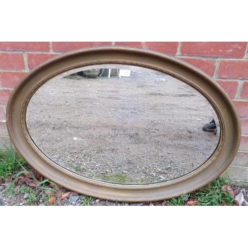 815 - An antique oval bevelled wall mirror, within a gilt frame with reeded decoration. 
H62cm W88cm D4cm ... 