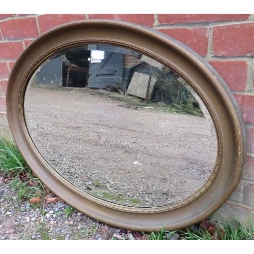 815 - An antique oval bevelled wall mirror, within a gilt frame with reeded decoration. 
H62cm W88cm D4cm ... 