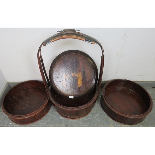 829 - An early 20th century Chinese bamboo wedding basket, of three stacking sections with bentwood carry ... 