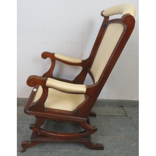 840 - An early 20th century American mahogany ‘Dexter’ rocking chair, re-upholstered in cream leather with... 