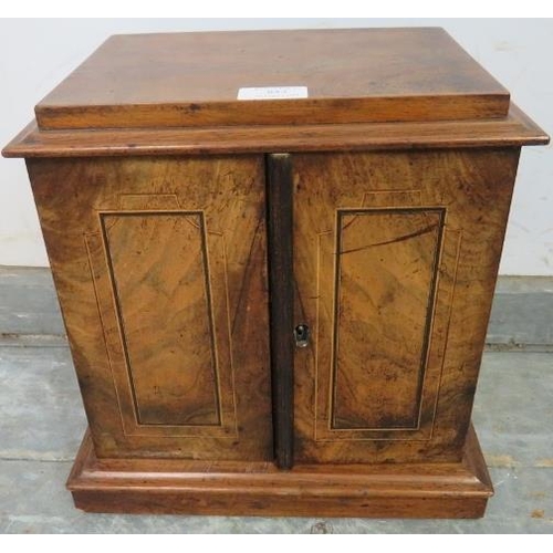 852 - A Victorian figured walnut table top cabinet, the twin doors with ebony and satinwood inlay, opening... 